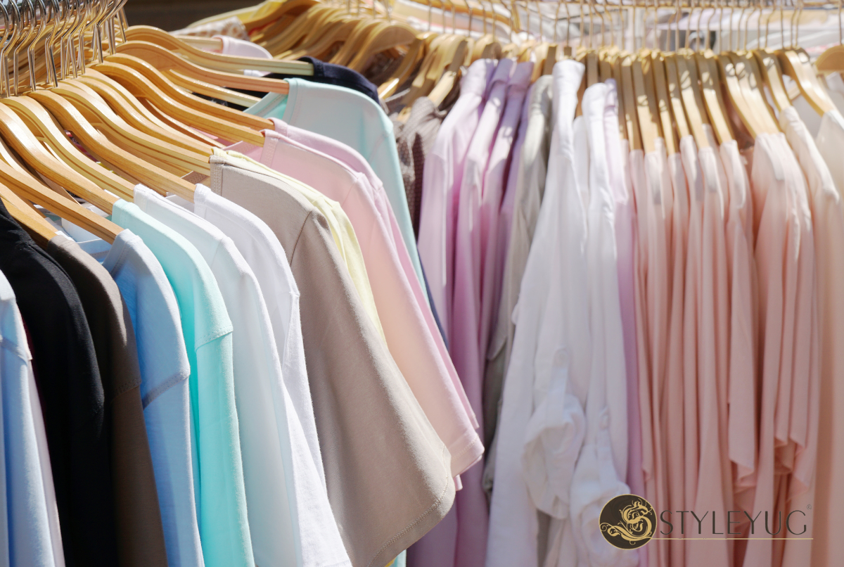 Deretan pakaian warna pastel—baby pink, mint, lilac—tergantung rapi di rak butik minimalis.