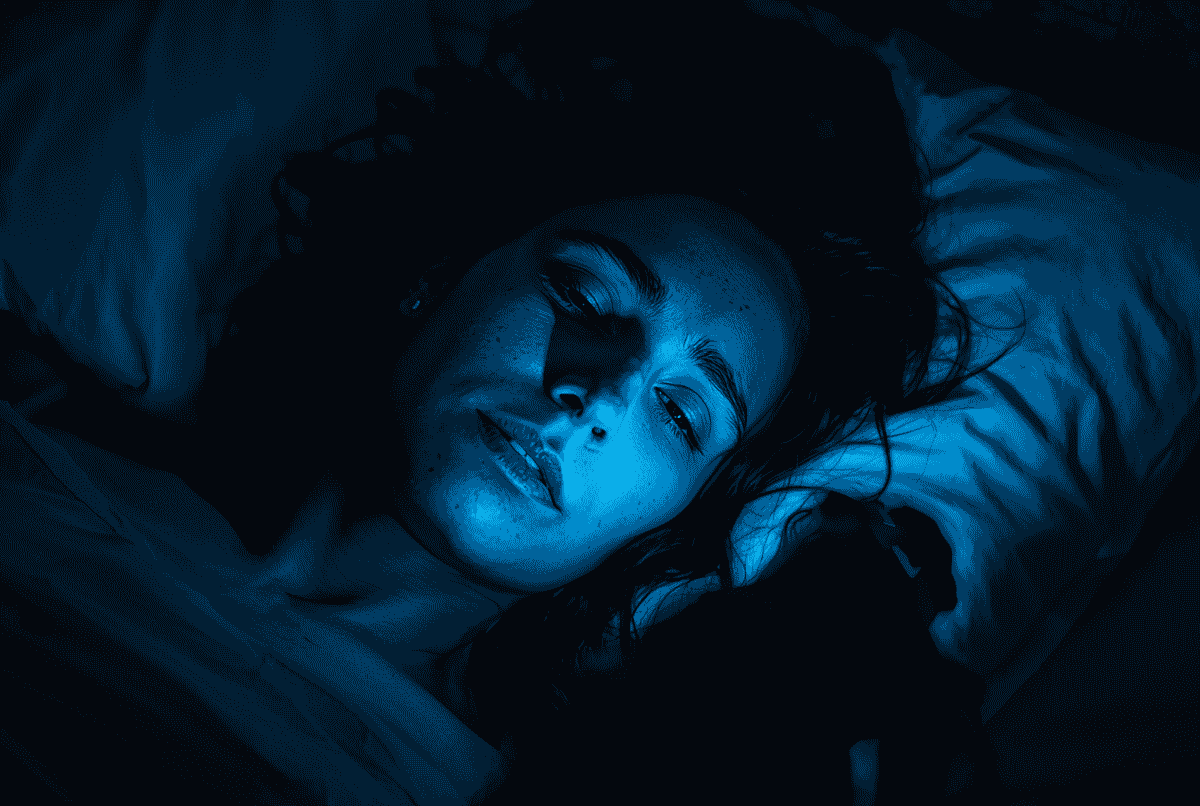 Wanita terjaga di malam hari terkena cahaya biru dari layar ponsel.